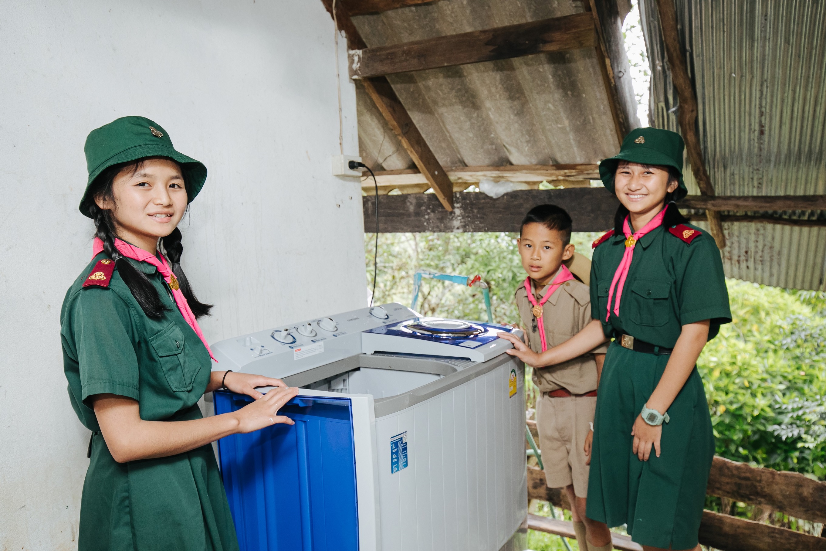 학생들이 웃는 얼굴로 삼성전자가 홍수 피해 지역에 기증한 세탁기를 둘러싸고 있다. 