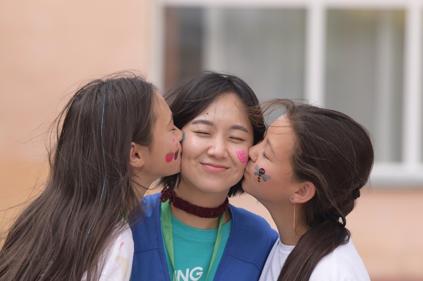 현지 맞춤형 임직원 봉사단 ‘삼성 원위크(OneWeek)’가 카자하스탄을 방문했다. 봉사자의 양 볼에 아이들이 입맞춤을 하고 있다.