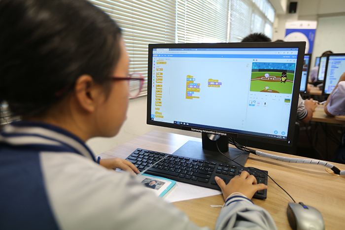 안경을 낀 여학생이 강이실 에서 게임을 접목한 컴퓨터 교육에 참여 하고 있다. 