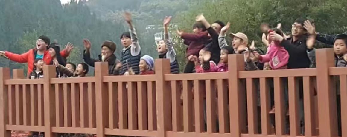 People waving while standing on a newly completed bridge