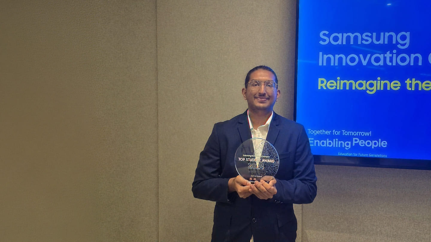 Abhinav Kottayil is posing for a commemorative photo while holding the SIC Best Student Award.