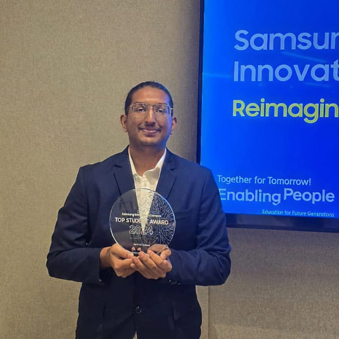 Abhinav Kottayil is posing for a commemorative photo while holding the SIC Best Student Award.