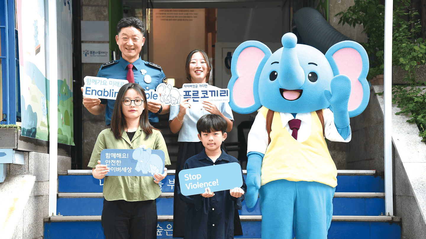 Children with a smile on their face and Blue Elephant mascot waving its hand